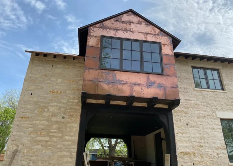 Copper metal panel facade on a stone building for Roof Repair in Malone
