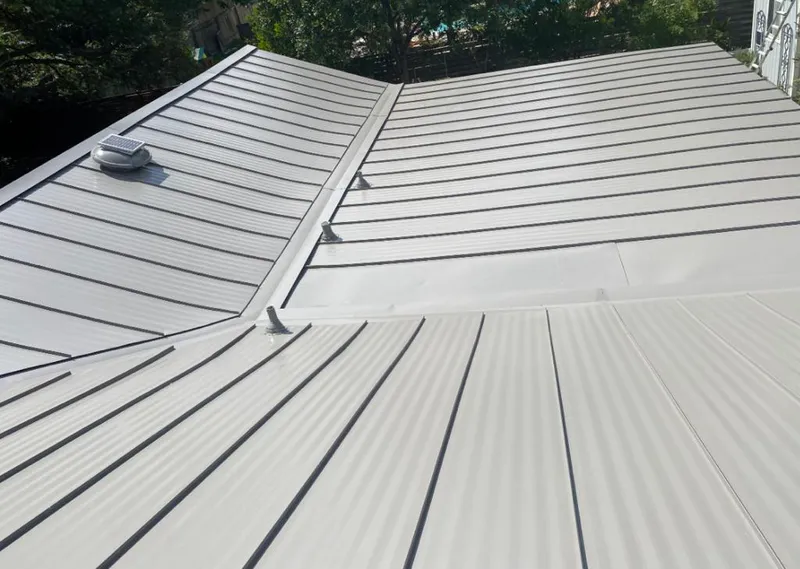 Solar attic fan installed on a metal roof for Roof Ventilation in Malone